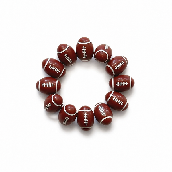 A circular beaded bracelet made of football-shaped beads in dark brown with white laces, photographed on a clean white background.
