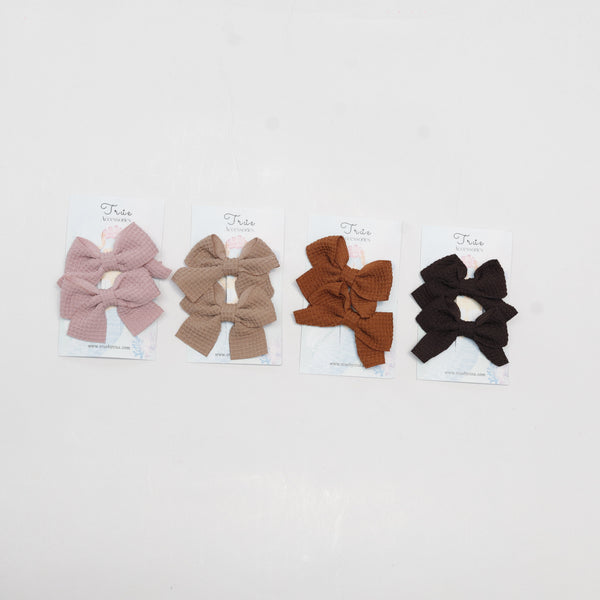 Four hair accessories (two bows and two scrunchies) on a white background