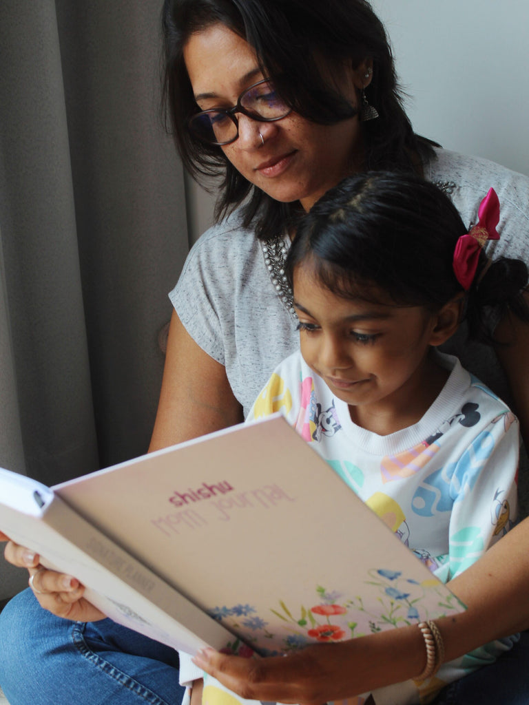 Mother reading the Mom Journal with her daughter 