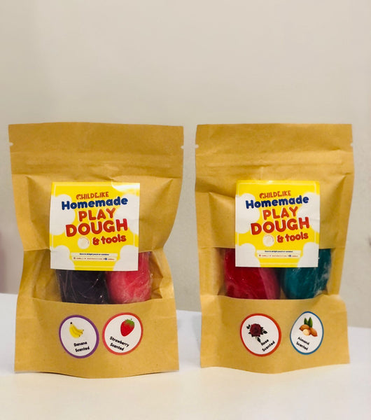 Two packages of Non-Toxic Homemade Scented Play Dough & Tools. Each package contains colorful play dough and tools, sealed in a brown paper bag with labels indicating the scent and contents.