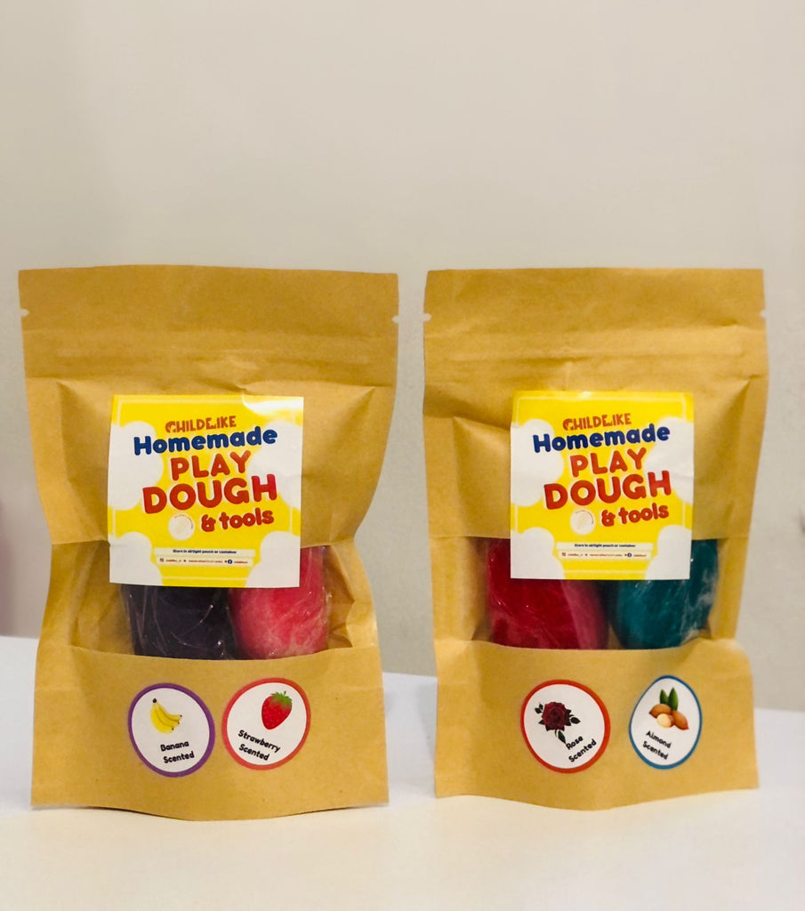 Two packages of Non-Toxic Homemade Scented Play Dough & Tools. Each package contains colorful play dough and tools, sealed in a brown paper bag with labels indicating the scent and contents.