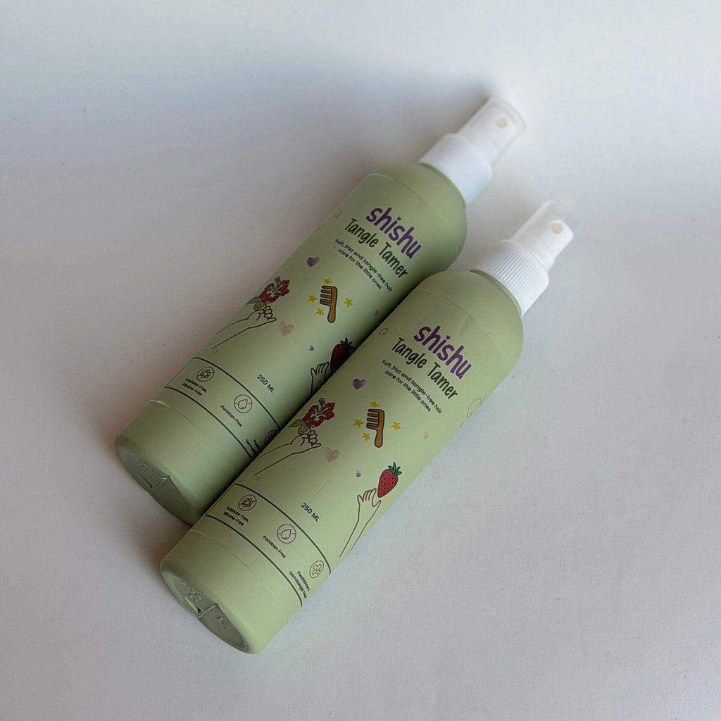 Two green bottles with white nozzles on a light gray background