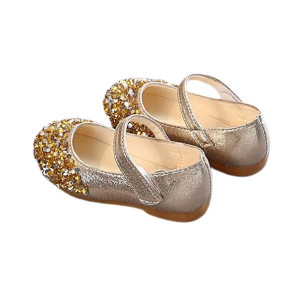 A pair of toddler-sized sparkly party shoes with gold and silver colors, featuring a flat sole and decorative glitter on the top.
