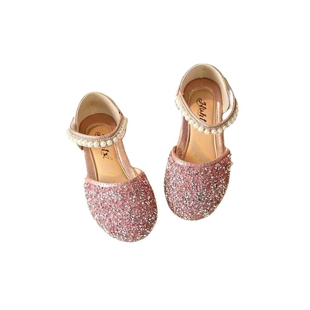 Pair of pink glitter shoes with pearl straps on a white background