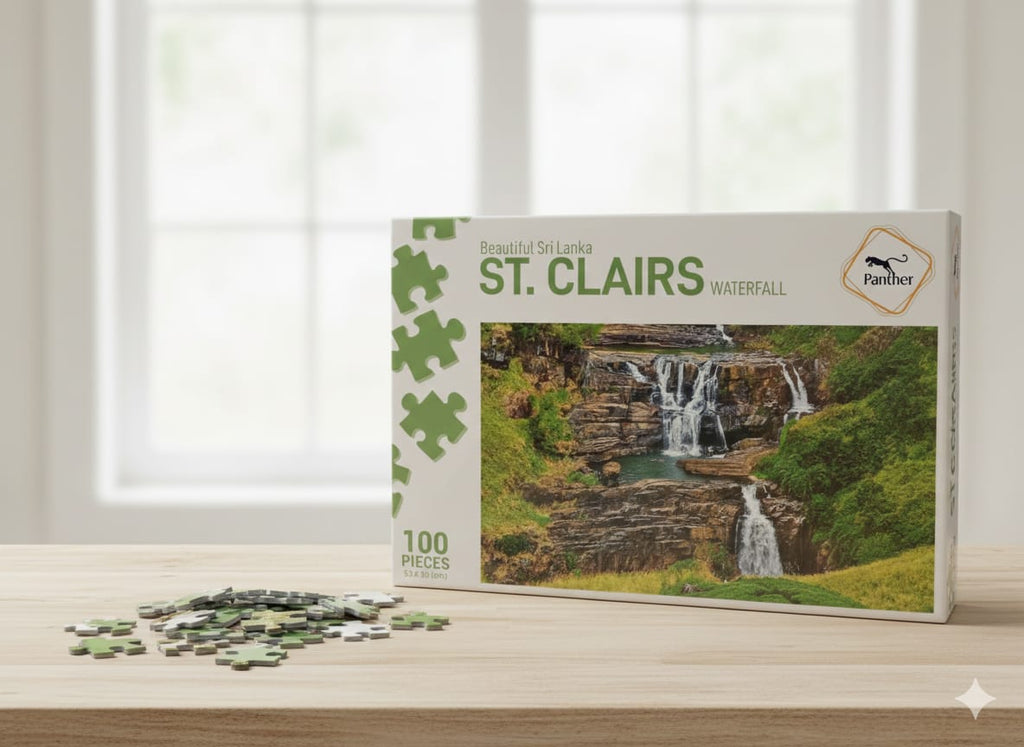Jigsaw puzzle box featuring a waterfall design on a wooden surface with a window in the background.