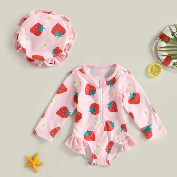 A pink baby girl's swimsuit with a strawberry pattern.