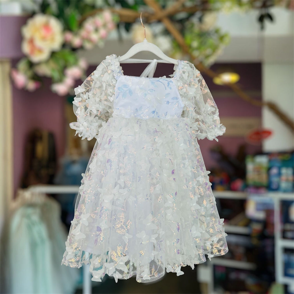 White floral dress on a hanger with a blurred indoor background