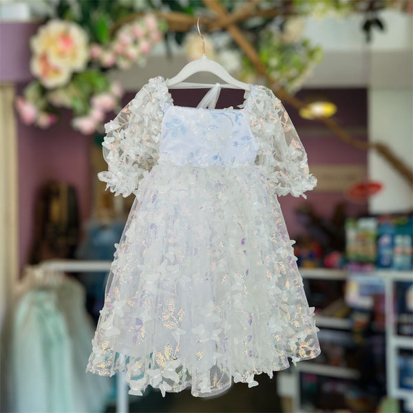 White floral dress on a hanger with a blurred indoor background