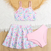 A three piece pink floral swimsuit with a skirt, consisting of a pink floral tank top, a pink floral skirt, and a pink swim skirt.