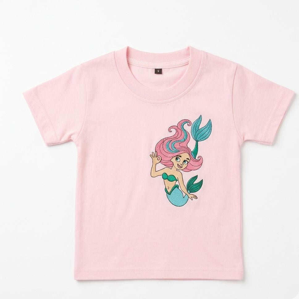 Pink t-shirt with a mermaid graphic on a white background