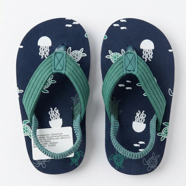 Pair of navy blue flip-flops with green straps and sea-themed design on a white background