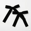 Two black velvet bows on a white background