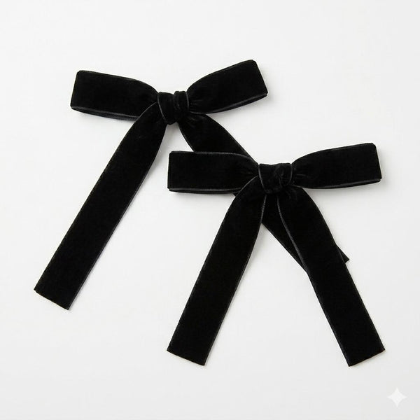 Two black velvet bows on a white background
