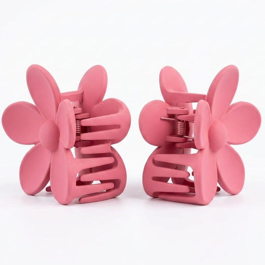 Two pink flower-shaped hair clips on a white background