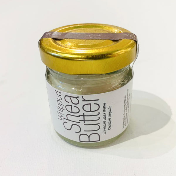 A jar of Whipped Shea Butter with a gold lid and a label that reads 'Shea Butter'.
