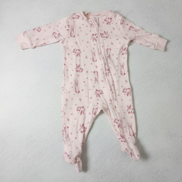 Pink baby onesie with floral pattern on a light gray background
