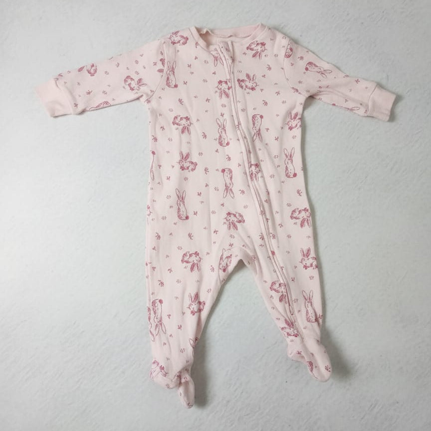 Pink baby onesie with floral pattern on a light gray background