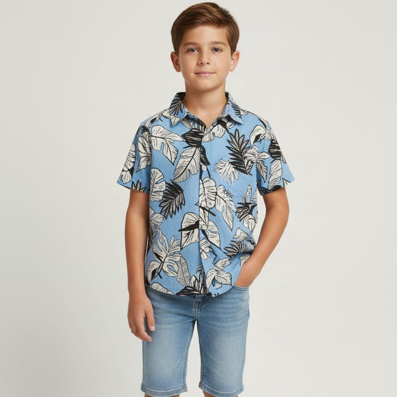 Child wearing a blue floral shirt and denim shorts on a white background