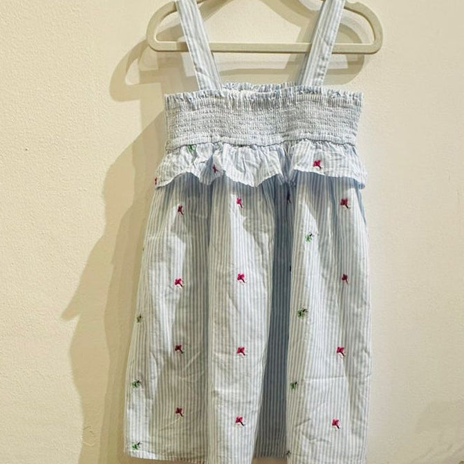 Striped dress with floral embroidery on a beige background