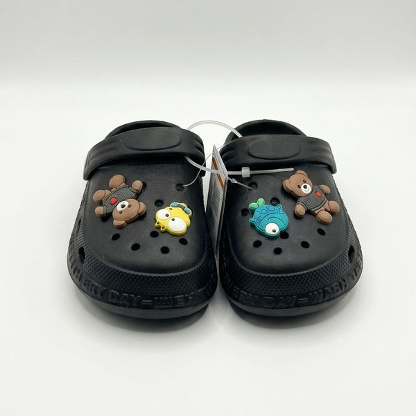 Black clogs with decorative charms on a white background