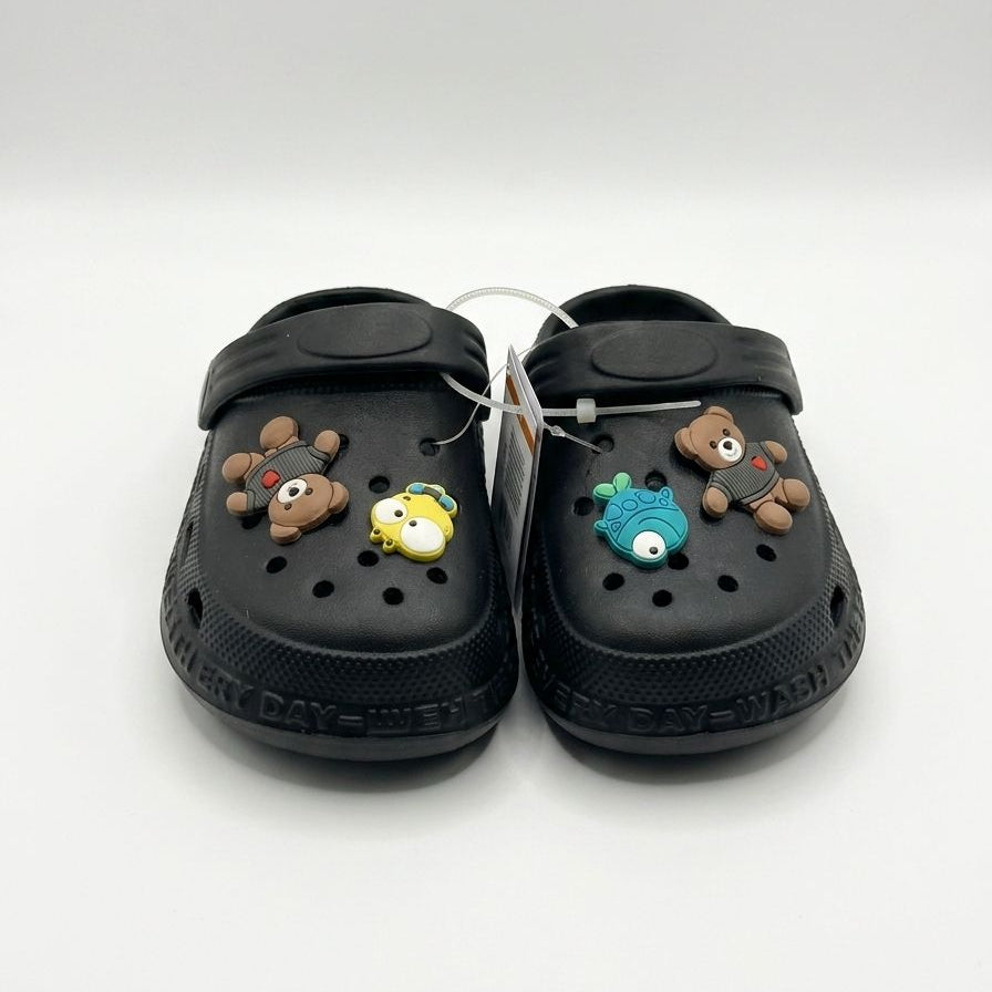 Black clogs with decorative charms on a white background