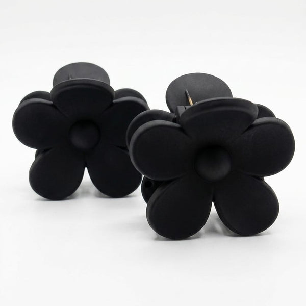 Black flower-shaped earrings on a white background