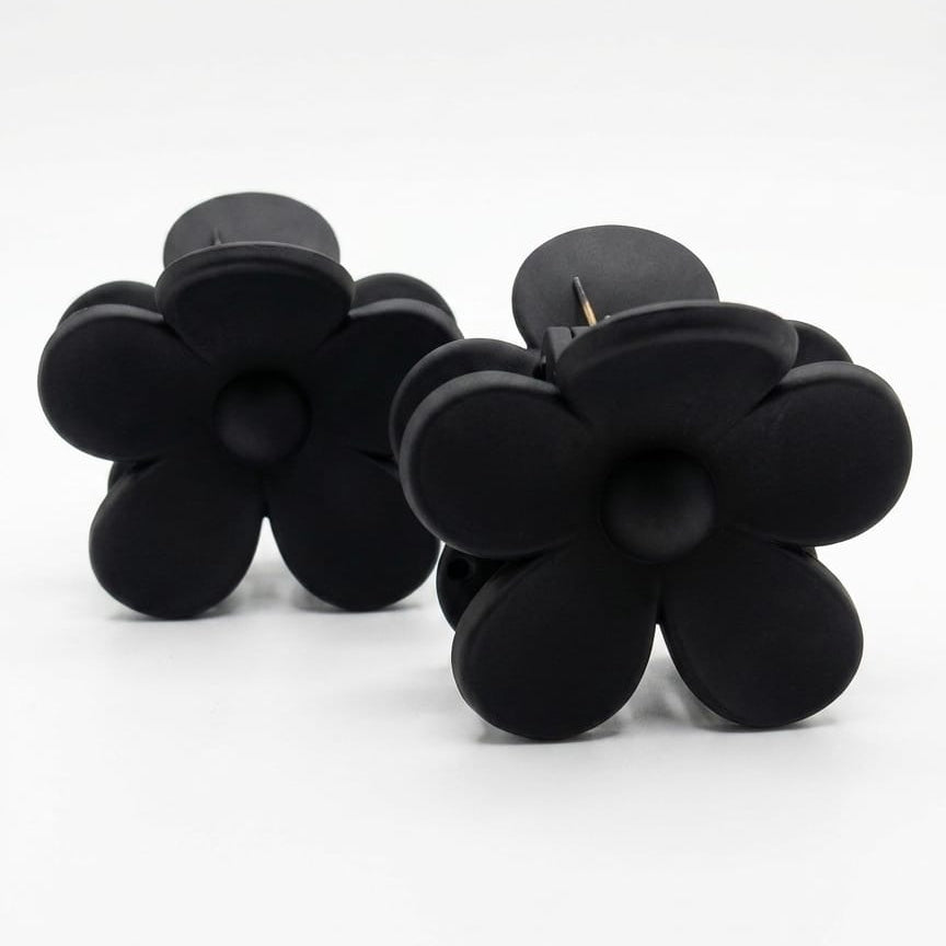 Black flower-shaped earrings on a white background