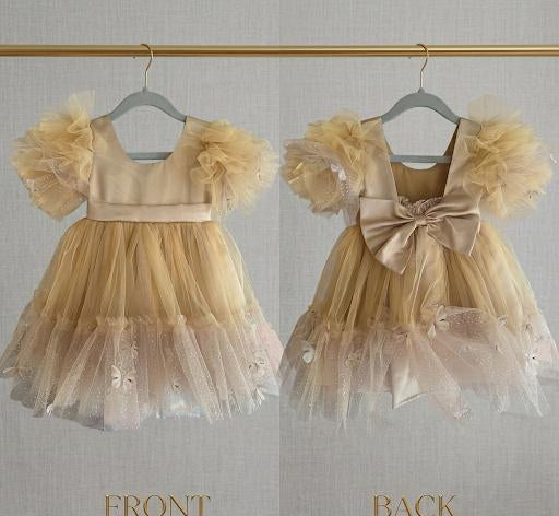 Two children's dresses on hangers, one front and one back view, against a neutral background.