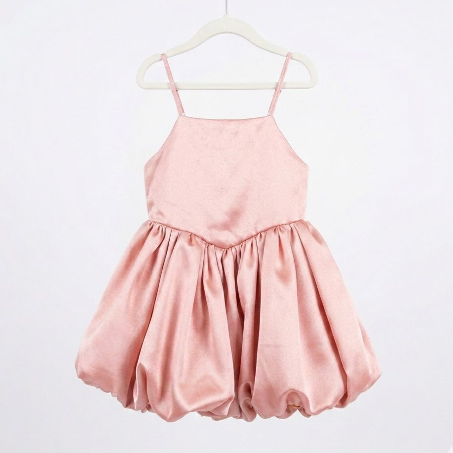 Pink dress on a hanger against a white background