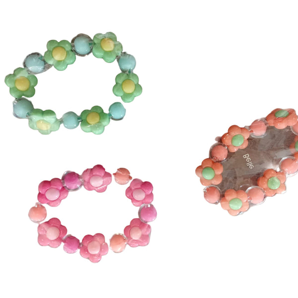 Three floral-patterned hair ties in green, pink, and orange on a white background.