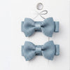 Two blue ribbed hair bows on a white background