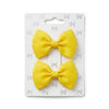 Two yellow hair bows on a white card with a pattern of small bows.
