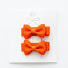Two orange bows on a white background