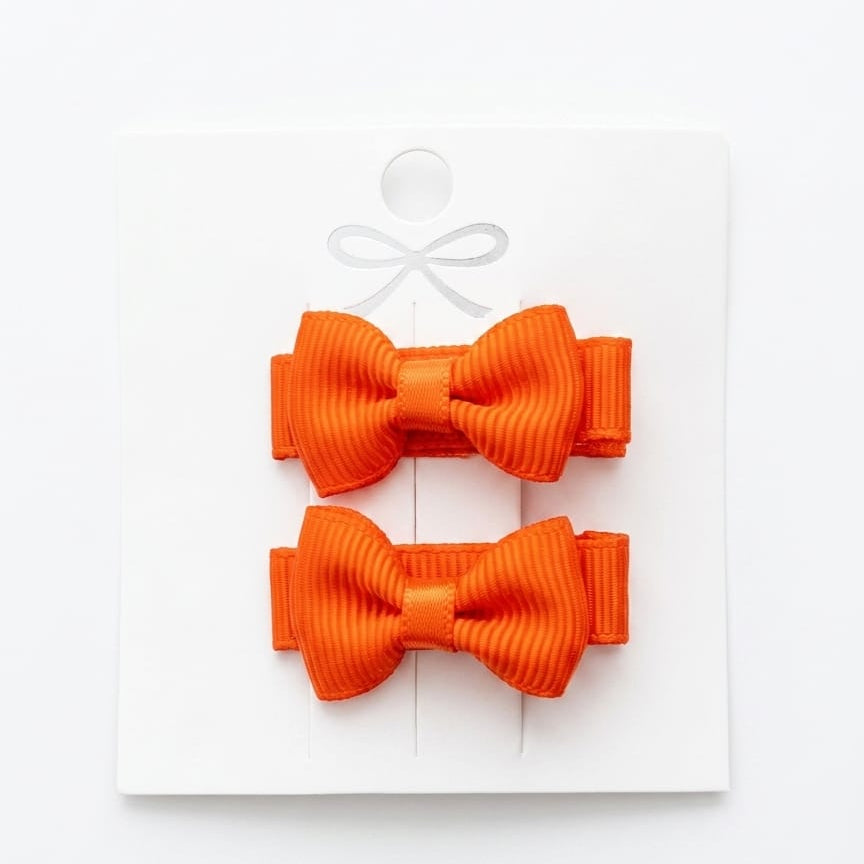 Two orange bows on a white background