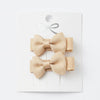 Pair of beige hair bows on a white background