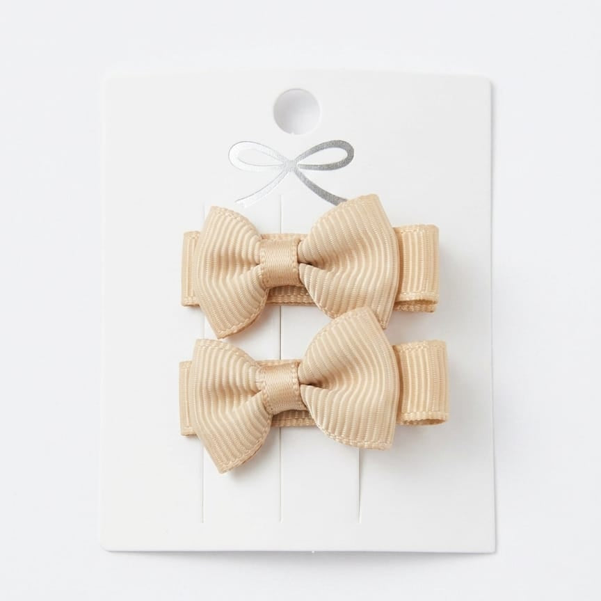 Pair of beige hair bows on a white background