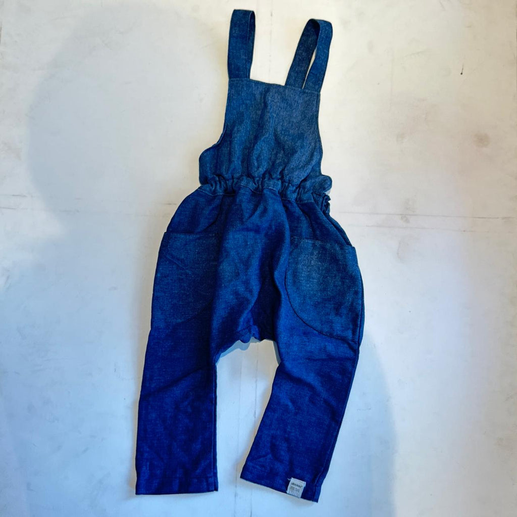 Blue denim overalls on a light wooden surface