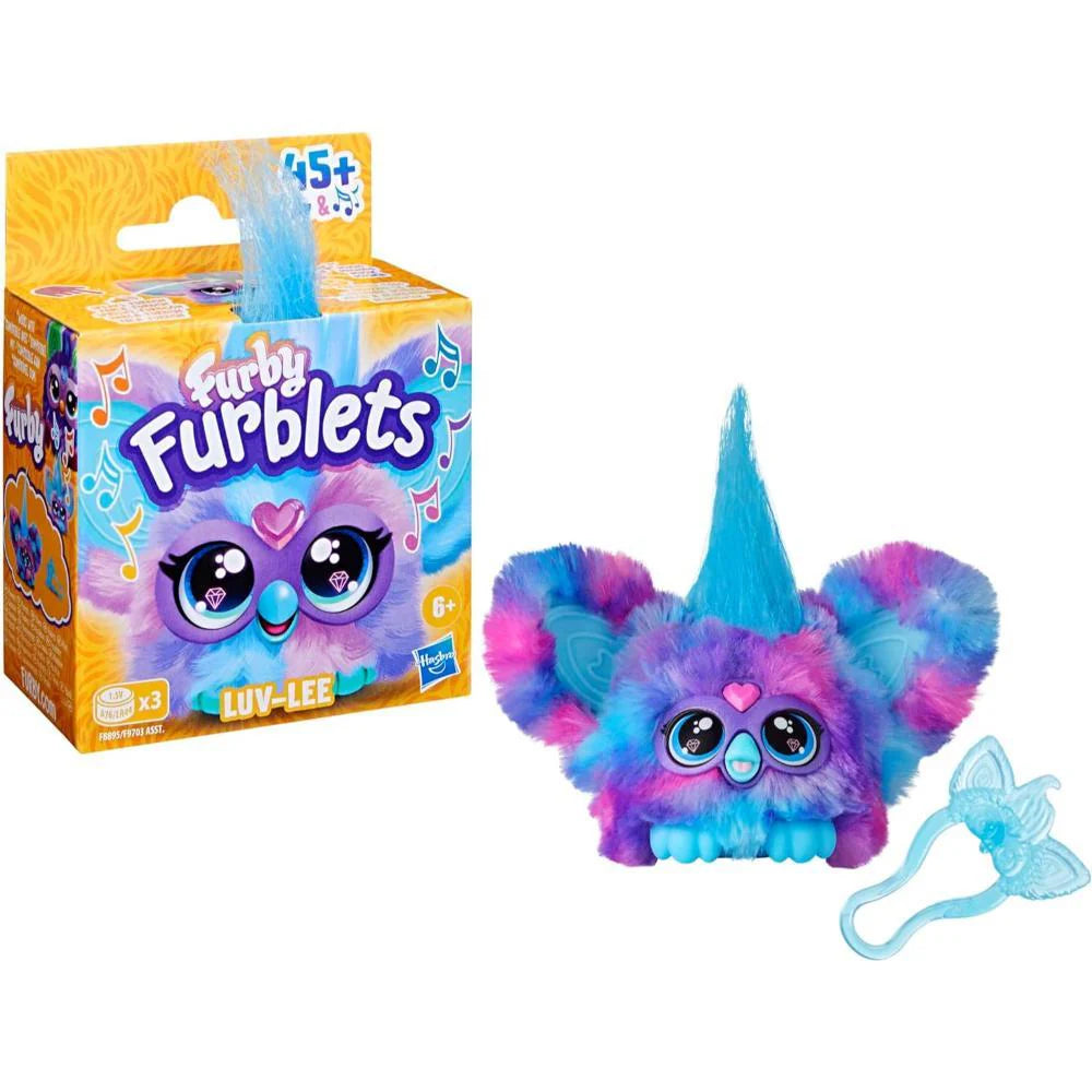Packaging and a mini Furby electronic toy named Luv-Lee with multicolored fur, displayed with a keychain clip.