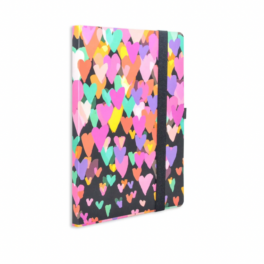 A multicolored journal notebook with a heart pattern on the cover, featuring a black elastic band and a pen loop.