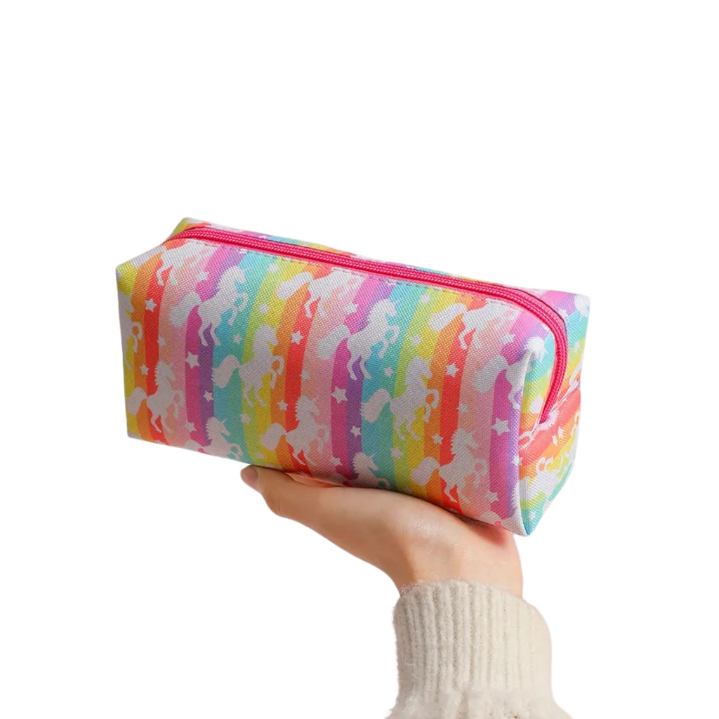 A multicolored pencil case with a unicorn pattern being held in a person's hand.