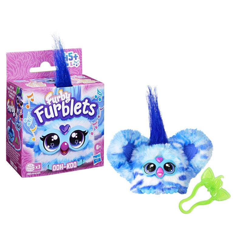 Packaging and toy version of the Furblets mini Furby electronic toy, showing the product with blue and white striped fur and its retail box.