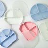 Few True Silicone Divided Smile Plates with Lid, in pastel pink and blue. These BPA-free, food-grade silicone plates are perfect for mealtime.