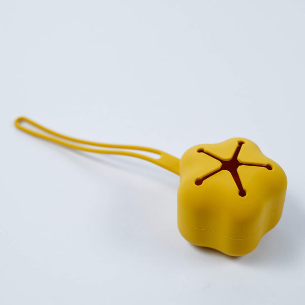 A yellow pacifier case with a starry slit design, attached to a clip.