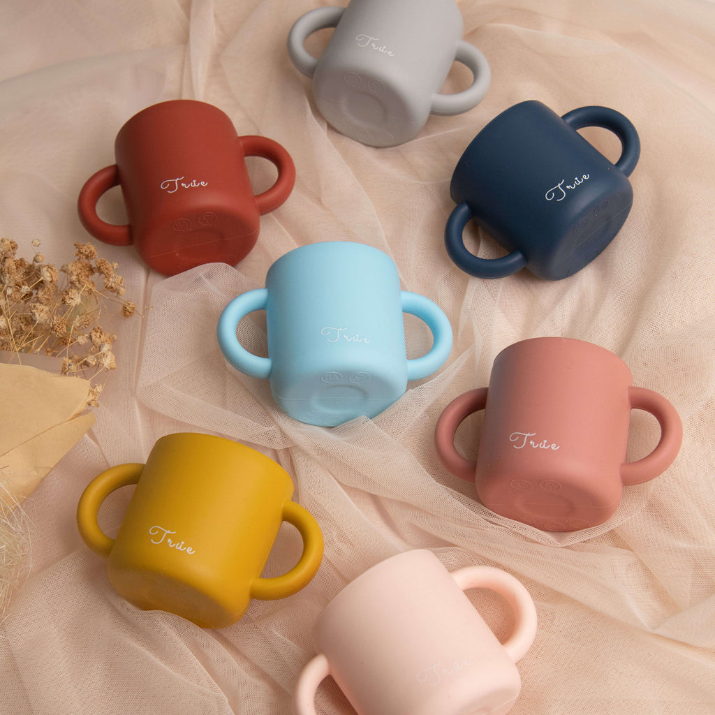 A collection of silicone double handled cups in various colors, each with the brand name 'True' on the side.